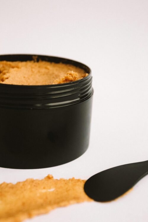 High-quality cosmetic cream in a sleek black jar on a white background, perfect for skincare marketing.